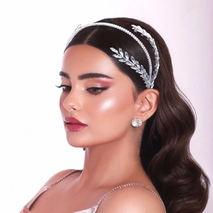 Close-up of bridal crystal headband and earrings set with elegant silver leaf design