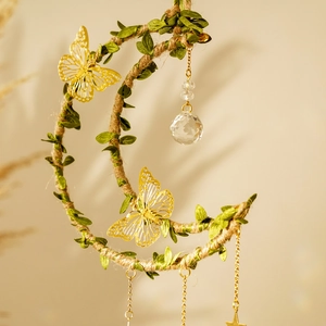 Close-up of crescent moon crystal catcher with golden butterflies and hanging prism ball