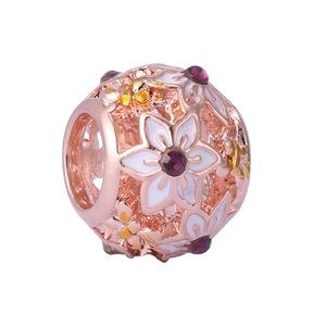 Close-up of rose gold hollow charm with white enamel flowers and purple gemstones