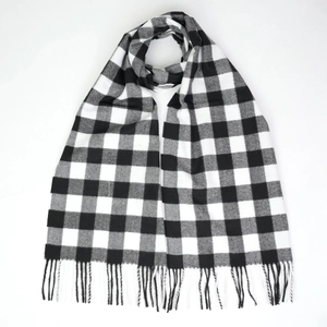 Close-up of black and white checkered scarf with soft fringed edges on white background