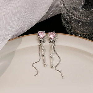 Detail of pink crystal heart earrings with silver bow and elegant long tassel chains