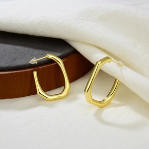 Minimalist 18k gold plated hexagon hoop earrings for women on a dark wooden tray