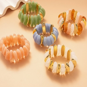 Macro view of five acrylic stretch bracelets in various colors with gold alloy spacers