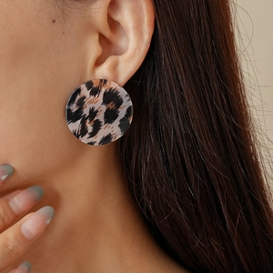 Vue détaillée d'une boucle d'oreille ronde en acrylique à motif léopard rétro portée