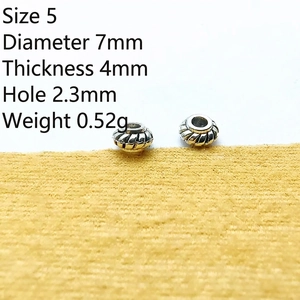 Detailed view of 7mm silver spacer beads with twisted texture and 2.3mm hole for DIY jewelry