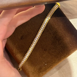 Vue détaillée du bracelet doré serti de zircons cubiques avec base à structure tissée