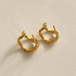 Macro shot of 925 silver gold-plated wavy pearl earrings showing the S925 hallmark