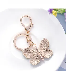 Detailed back view of a rose gold butterfly keychain showing textured alloy and rhinestones