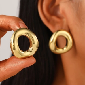 Detailed view of polished gold chunky earrings showing organic irregular curves and luster