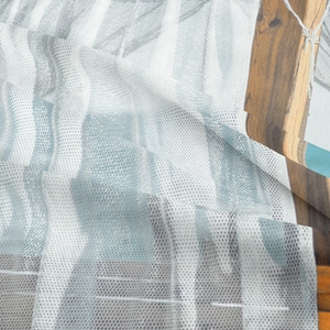 Close-up of translucent mesh tapestry with abstract geometric print and light texture