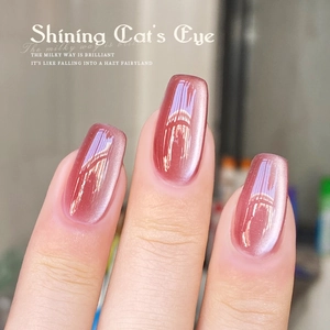 Pink cat eye nail polish with a shimmering milky way effect on manicured fingers