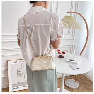 Detailed view of a white embroidered Qipao handbag with gold chain and vintage kiss lock