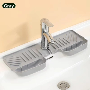 Close-up of gray silicone faucet splash guard draining water into a white sink