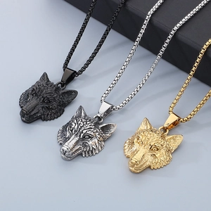 Macro shot of Viking wolf head pendants in black, silver, and gold stainless steel finishes