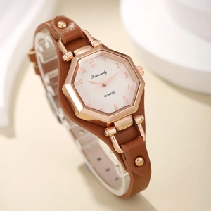 Détail du boîtier hexagonal en or rose et du bracelet en cuir marron avec rivets