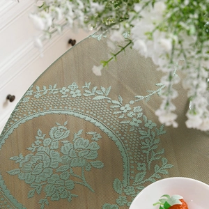 Elegant beige oval placemat with green rose floral pattern on a rustic wooden table