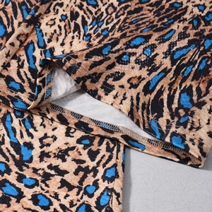 Detailed close-up of leopard print stitching and textured stretch fabric on trousers