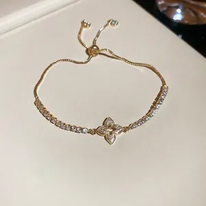 Elegant gold adjustable bracelet featuring a diamond-encrusted four-leaf clover charm