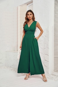 Detail of dark green sleeveless jumpsuit with textured fabric and V-neckline high waist