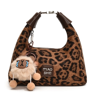 Leopard print plush shoulder bag with brown strap and cute sheep charm on white background