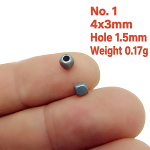 Detail of 4x3mm matte grey metal spacer bead held by fingers for scale, hole size 1.5mm