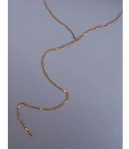 Detail shot of the 18k gold y2k tassel layered necklace on a neutral background