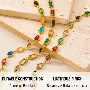 Detailed shot of gold chain bracelet with colorful geometric multi-gemstones on stone