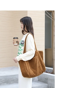 Outdoor lifestyle shot of a brown corduroy tote bag featuring a large front pocket