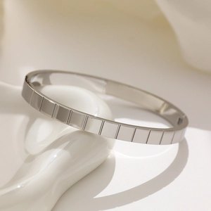 Elegante bracciale in acciaio inossidabile argento con motivo a griglia su vassoio bianco