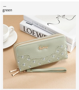 Detail of green long wallet with quilted pattern, flower motifs, and wrist strap