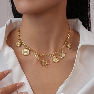 Dettaglio della collana dorata con ciondoli marini conchiglie e stelle sulla modella