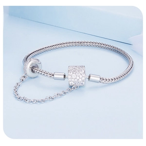 Macro shot of silver woven snake chain bracelet featuring a sparkling zircon pavé cylinder