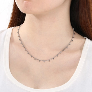 Vue détaillée d'un collier chaîne à perles argentées ajustable porté par un mannequin