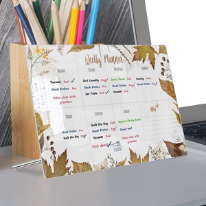 Clear acrylic weekly planner on desk featuring autumn floral patterns and metal stand