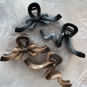 Chic bow-shaped hair claws in black and brown gradients with stylish irregular lines