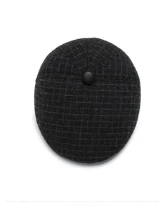 Top down view showing dark gray plaid wool flat cap with fine texture and button detail