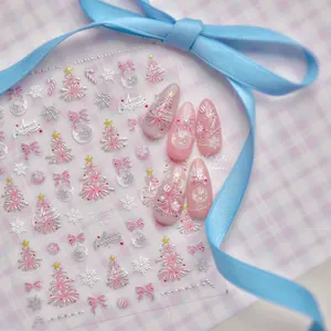 Close-up of 3D Christmas nail stickers with pink silver glitter trees and snowflakes