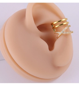 Vue détaillée d'un ear cuff doré à trois couches avec zircons croisés sur modèle d'oreille