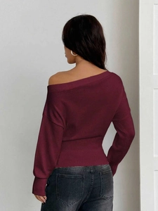 Détail arrière du pull en tricot bordeaux à épaules dénudées avec taille côtelée