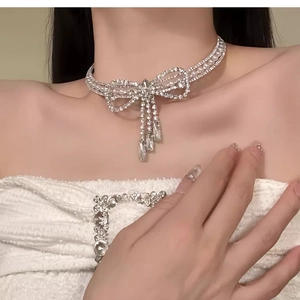 Detail einer eleganten Strass-Schleifen-Halskette mit Quaste an einem Modell