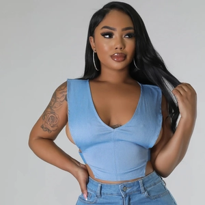 Détail du gilet en jean bleu avec décolleté en V profond et boutons métalliques