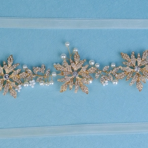 Detail of golden bridal headband featuring alloy flowers, rhinestones, and pearls