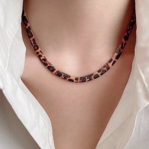 Nahaufnahme der Retro-Halskette mit Leopardenmuster und flacher Schlangenkette