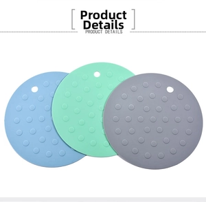 Detail of round silicone table mats with anti-slip dots and hanging holes in three colors