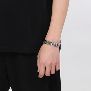 Close-up of a silver stainless steel double woven Cuban link chain bracelet on wrist