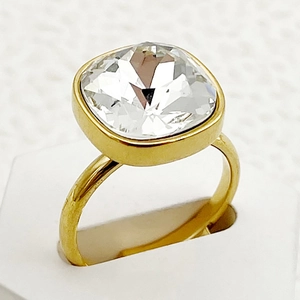 Vue macro d'une bague en acier doré avec un zircon cubique transparent de taille carrée