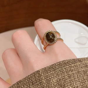 Detail of 18k gold plated tiger eye ring with a vintage beaded band on a finger