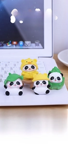 Set of four cute panda figurines with diverse hat designs on a laptop keyboard