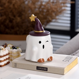 Detail of cute ghost ceramic mug with a purple wizard hat lid and golden star accent