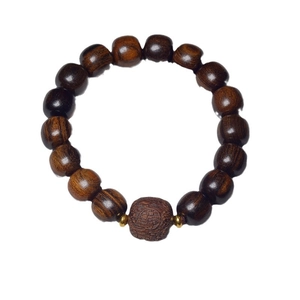 Dark brown wood bead bracelet featuring a carved Fu character and gold metal accents